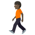 🚶🏿 person walking: dark skin tone display on JoyPixels